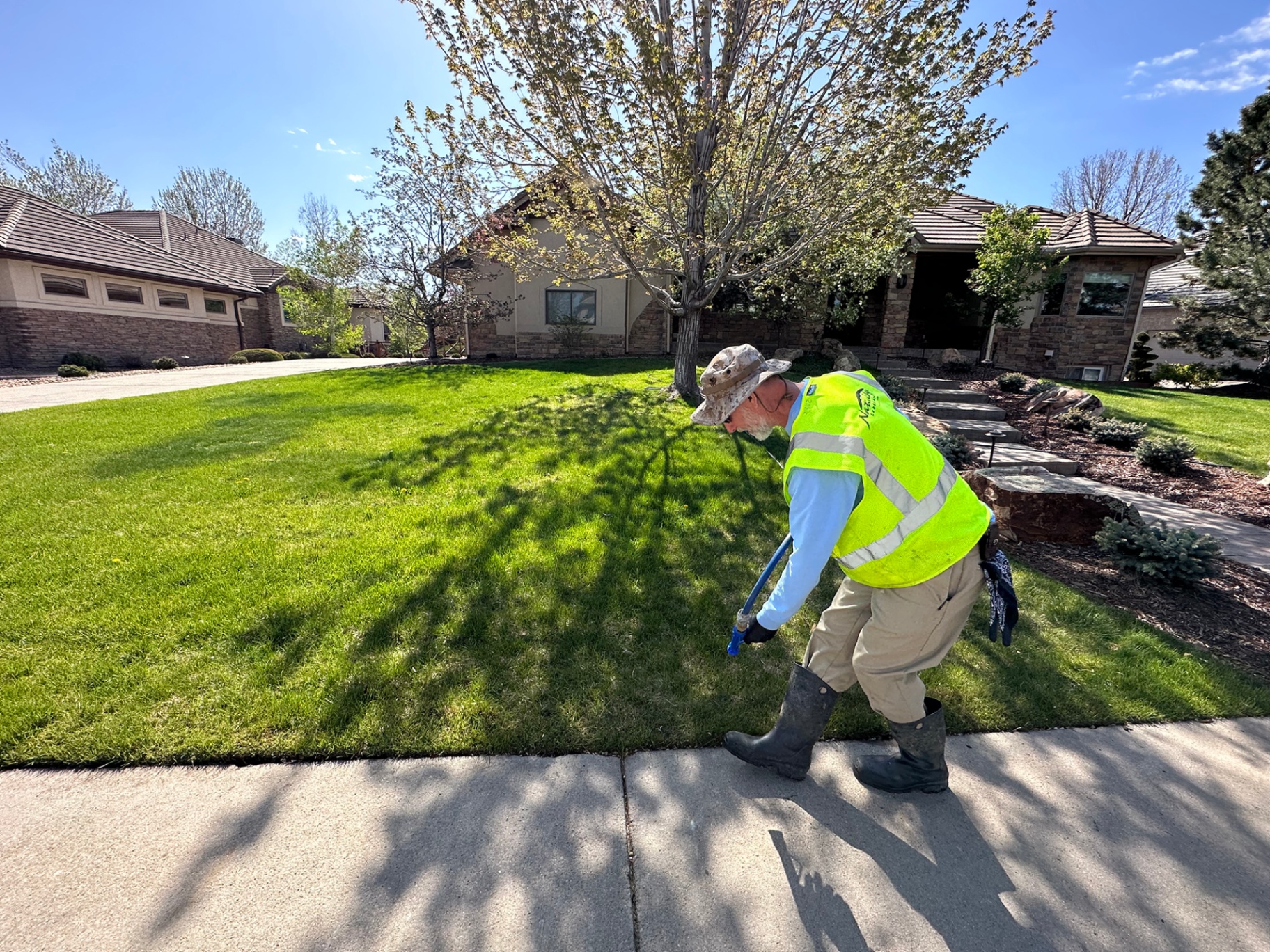 Property care technician treating a front lawn